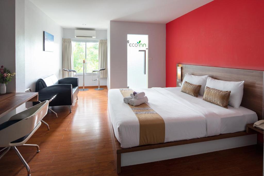 董里Eco Inn Prime Trang的一间卧室设有一张红色墙壁的大床