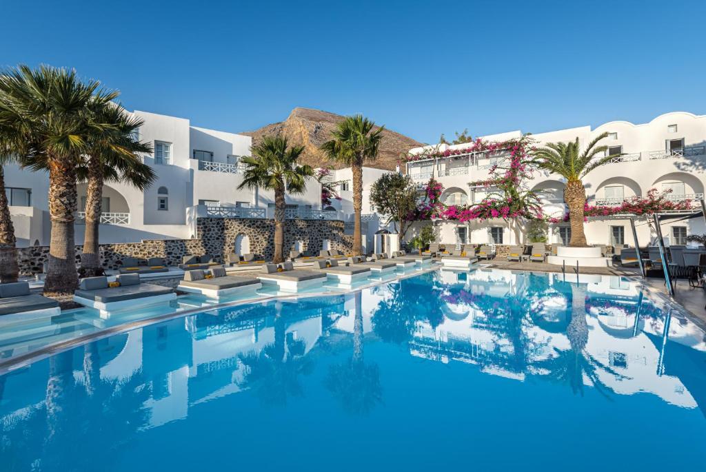 卡马利圣托里尼基萨莫斯度假酒店的一座棕榈树和建筑的大型游泳池