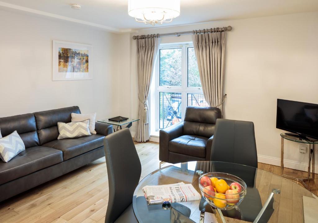 都柏林Baggotrath House Apartments, Newbridge Ave, Dublin 4的带沙发和玻璃桌的客厅