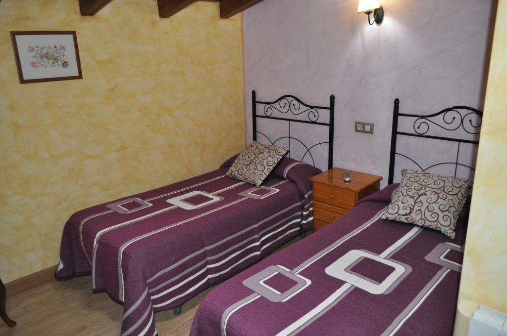 Los SantosCasa Rural Carpintero的紫色床单的客房内的两张床