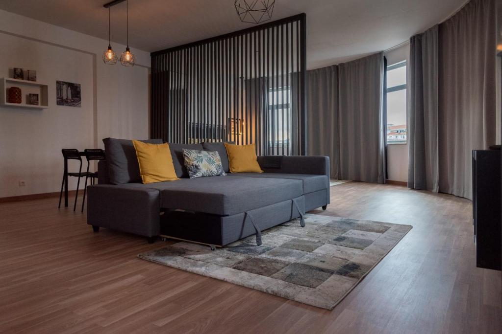 马塞杜-迪卡瓦莱鲁什Redondo Loft的客厅配有黑色沙发和黄色枕头