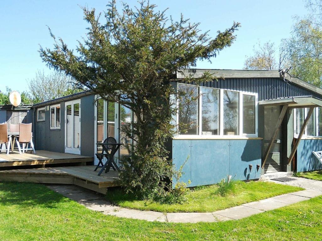 布罗艾厄4 person holiday home in Broager的前面有一棵树的蓝色小房子
