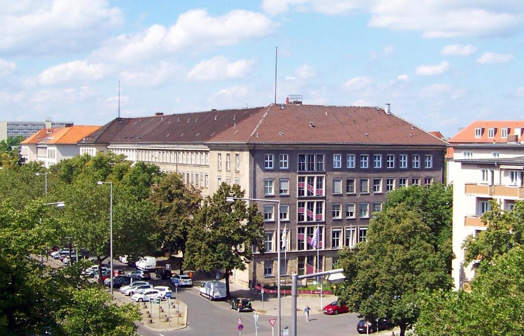柏林Hostel VITA Berlin的一座大建筑,在城市里设有停车场