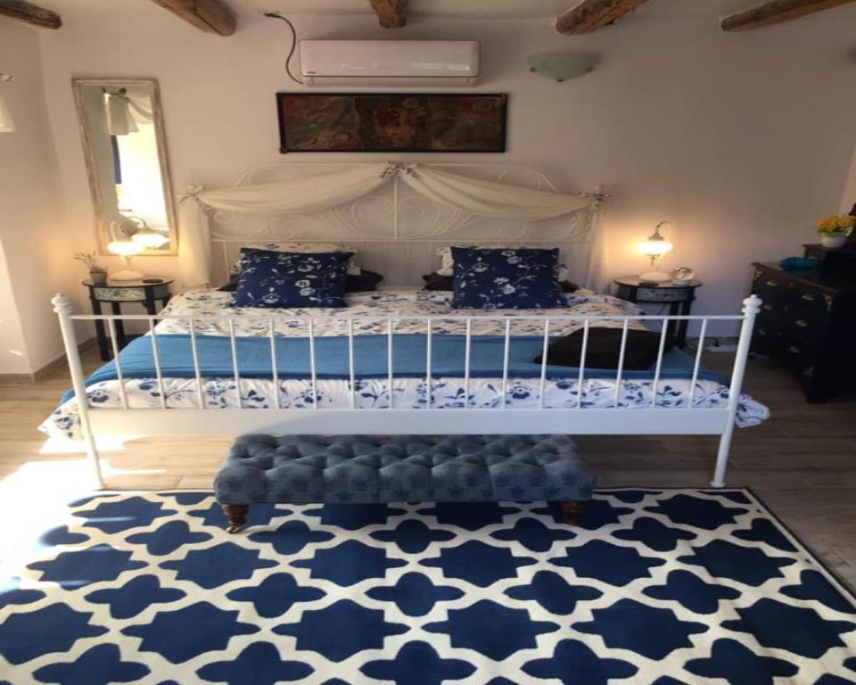 Stefan StambolovoSunflower Guest House Bulgaria的卧室配有白色床和蓝白色地毯。