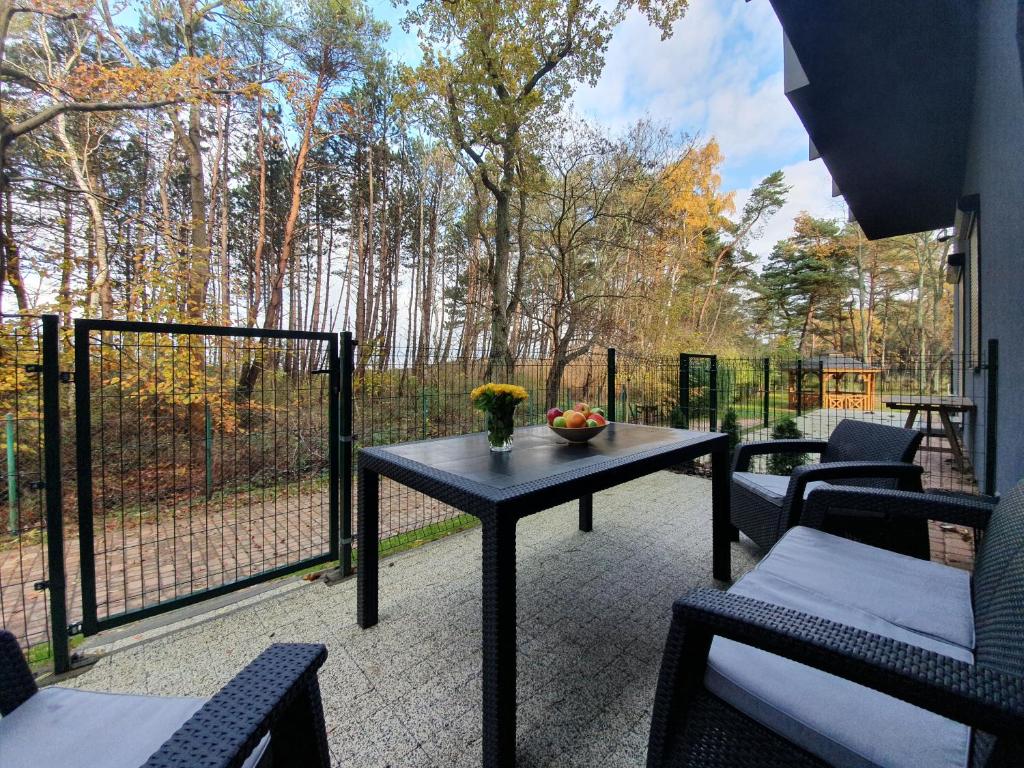 尤斯托尼莫斯基DWIE SOSNY-Apartament na wydmie - 365PAM的一个带桌椅和围栏的庭院