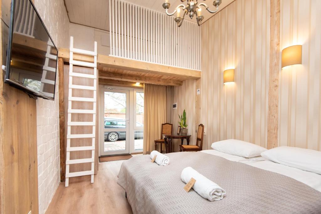 克莱佩达KUBU Loft的一间卧室配有一张床,上面有两条毛巾