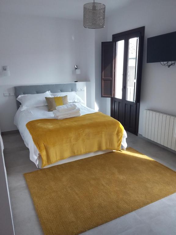 隆达Casa Clavero的一间卧室配有一张黄色毯子床