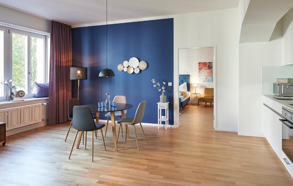 卢塞恩Neustadt Apartments managed by Hotel Central Luzern的一间拥有蓝色墙壁和桌椅的用餐室