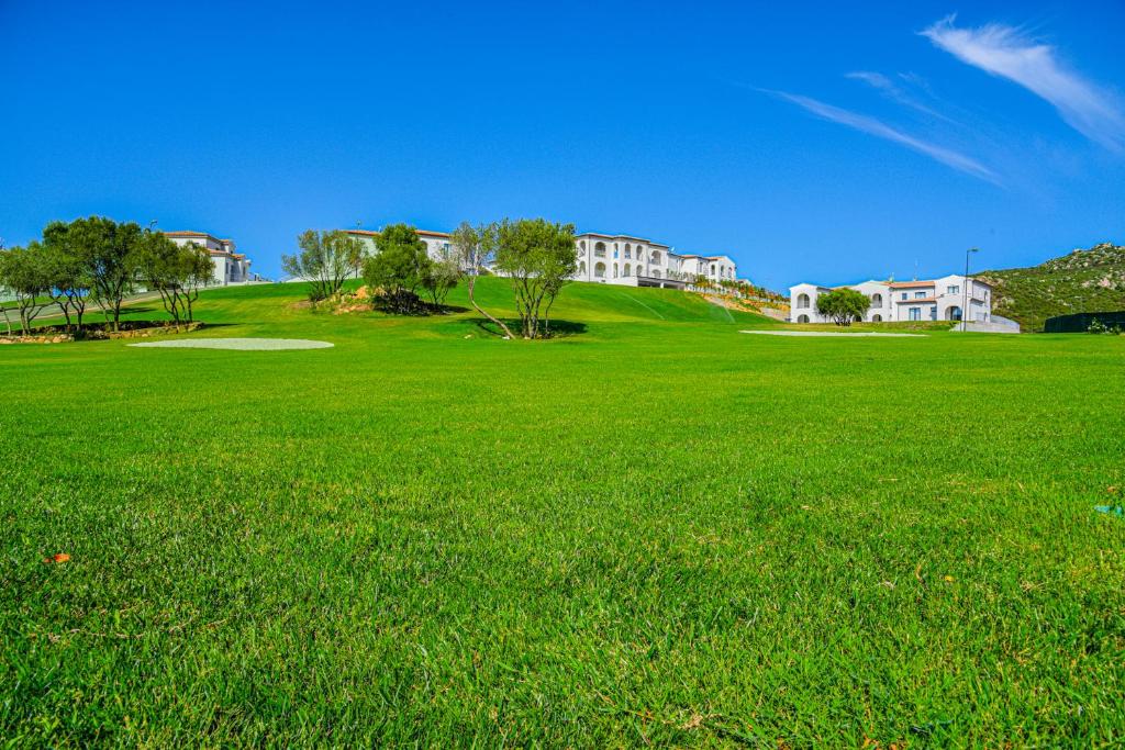 奥尔比亚Geovillage Green Residence的一片绿色的草地,有房子的背景