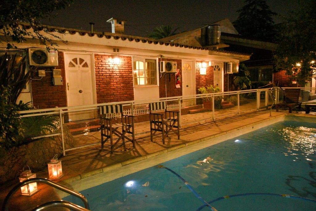 埃塞萨Bernie's Bed & Breakfast , A 3 KILOMETROS DEL AEROP EZEIZA, VAN ,IN-OUT, FREE EZEIZA AIRPORT的一座晚上设有游泳池的房子