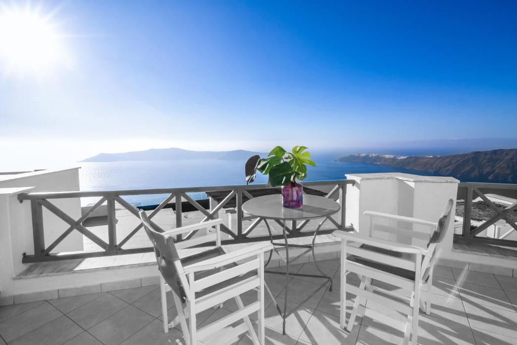 易莫洛林Abelonas Retreat的海景阳台上的桌椅
