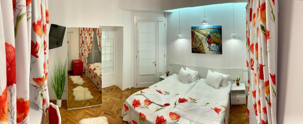 布加勒斯特Victoria Luxury Apartment 11的一间卧室配有白色床单和红色鲜花。