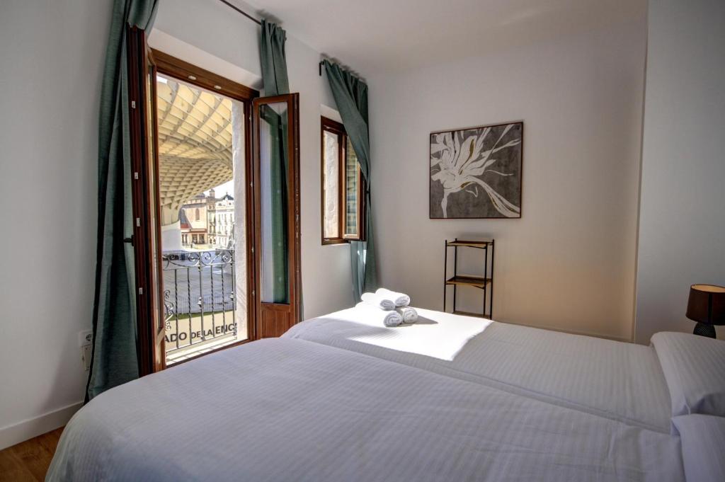 塞维利亚Apartamentos Setas Center的卧室配有白色的床和窗户。