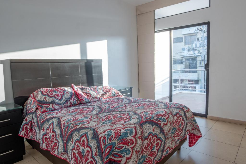 马萨特兰Apartamentos Torre II Condominios - Pet Friendly的一间卧室设有一张床和一个大窗户