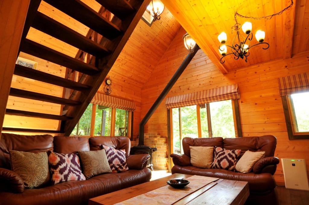 猪苗代町Log sweet Villa YU.CABIN / Vacation STAY 5351的客厅设有真皮沙发和木制天花板
