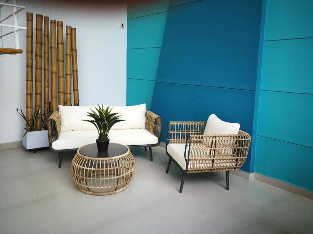 圣玛尔塔Acogedor Wind Playa Salguero frente al mar的一间房间,配有两把椅子和一张桌子,种植了盆栽植物