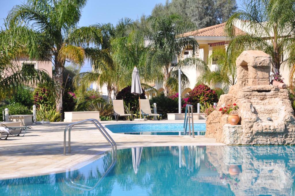 曼德里尔2 Bed, 2 Bath Apartment In Mandria的棕榈树度假村的游泳池