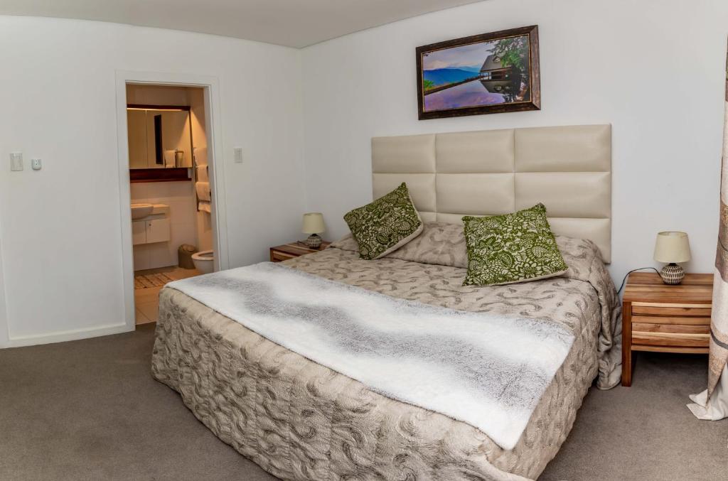 巴利托Zimbali Suite 213的一间卧室配有一张带绿色枕头的大床