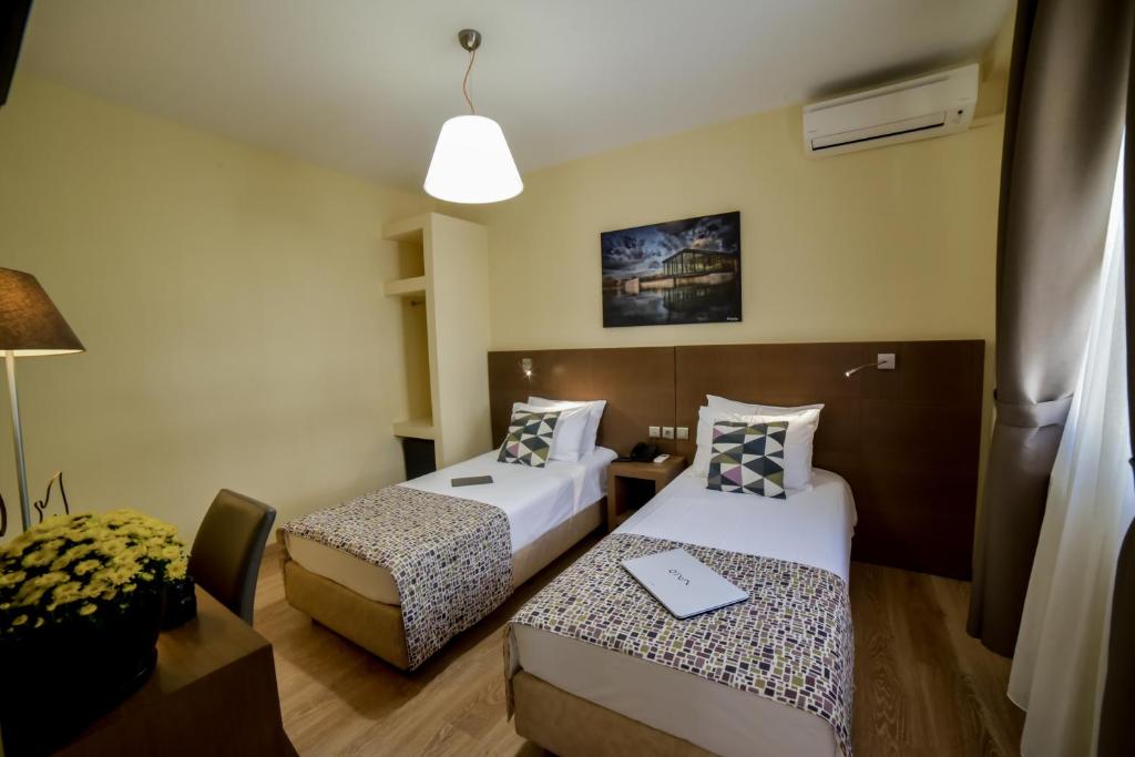 塞萨洛尼基奥勒斯塔斯卡斯托利亚酒店的酒店客房配有两张床和一张书桌
