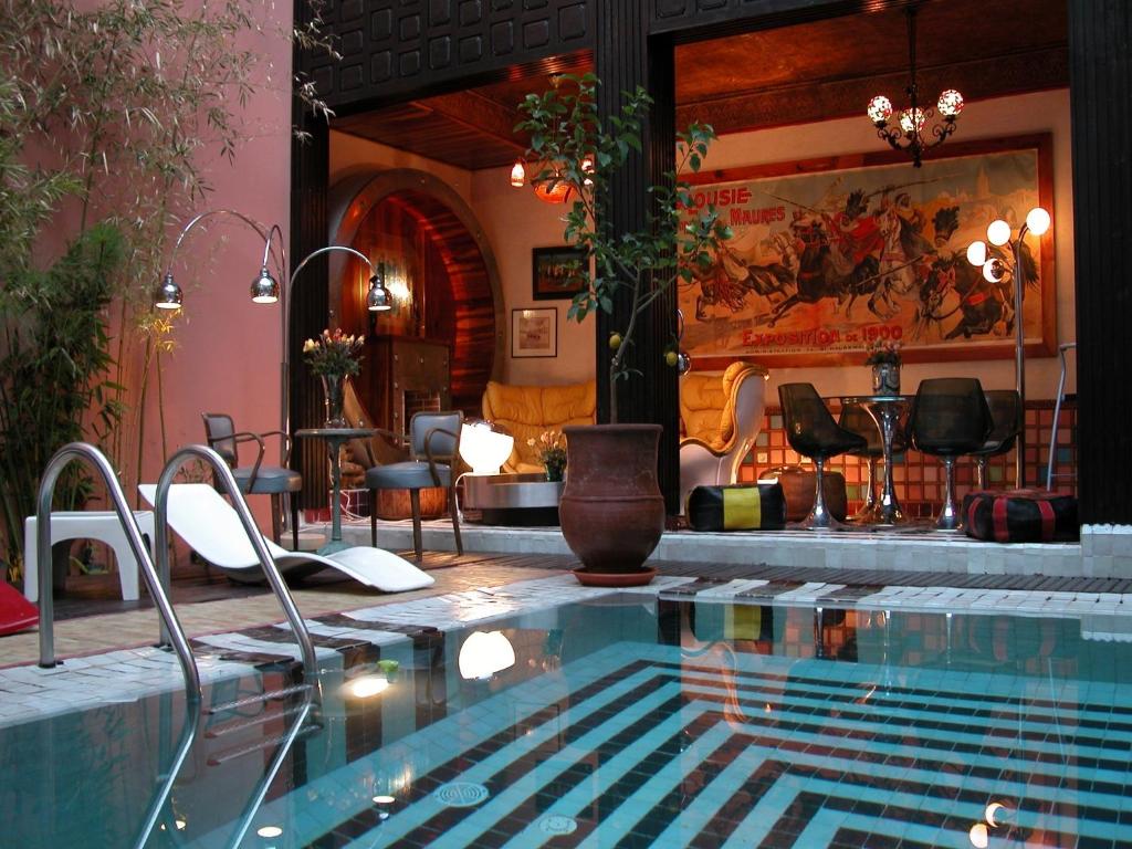 马拉喀什里亚德玛莉卡酒店的一个带椅子和桌子的大型游泳池