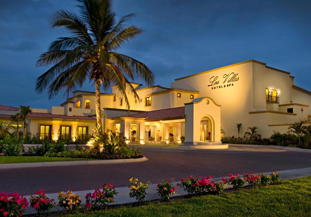 马萨特兰Las Villas Hotel & Golf By Estrella del Mar的前面有棕榈树的建筑