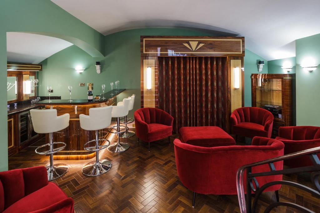 布莱顿霍夫Sea-facing Art Deco Apartment的一间酒吧,里面装有红色椅子和柜台
