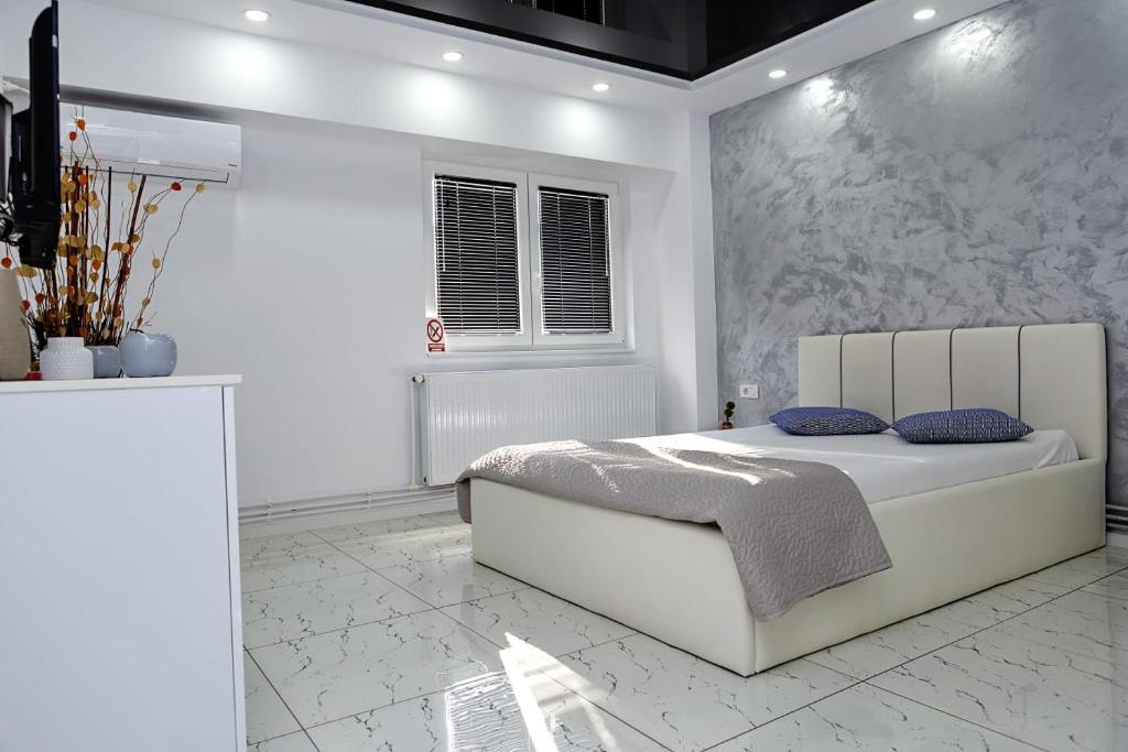 加拉茨Archi's Apartament的白色的卧室设有床和窗户