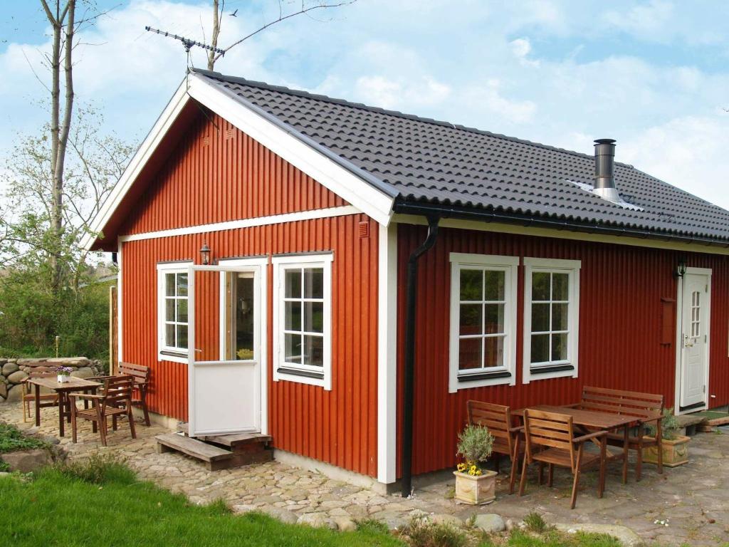 吉利勒杰6 person holiday home in Dronningm lle的红色的房子,配有野餐桌和椅子