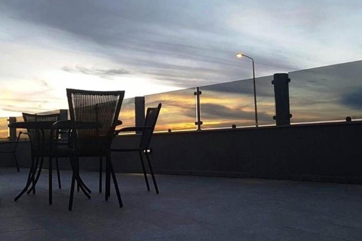 米茨佩·拉蒙צימרים שירת הכוכבים的阳台上配有两把椅子和一张桌子,享有日落美景