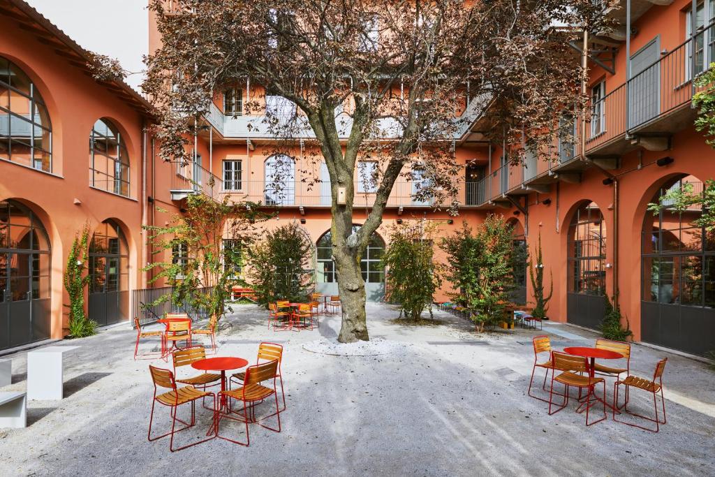 米兰Combo Milano的建筑前方的庭院配有桌椅