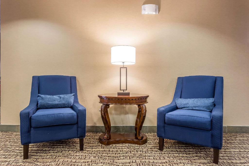 萨默维尔Quality Inn Summerville-Charleston的两张蓝色的椅子和一张带灯的桌子
