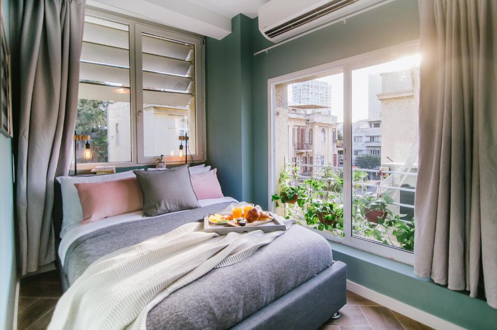 特拉维夫Monochrome Rothschild - Smart Hotel by Loginn Tel Aviv的一间卧室配有一张床,上面有水果盘