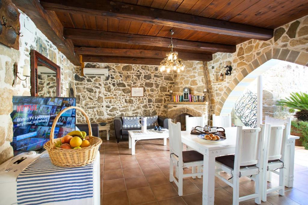 SívasVilla Epimenidis的一间设有桌椅和石墙的用餐室