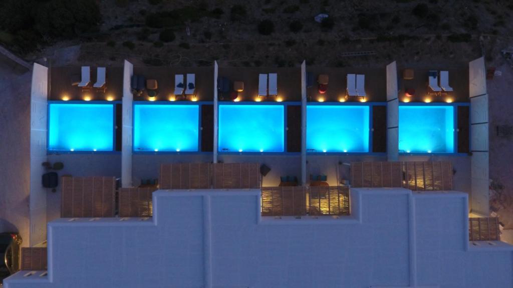 斯基罗斯岛Aelia Collection Suites - Adults Friendly的建筑中设有蓝色窗户,灯光亮丽