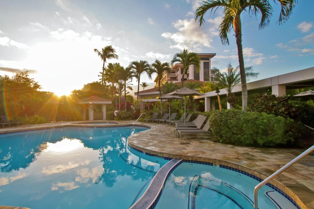 基黑茂宜海岸酒店的一座棕榈树游泳池和一座房子