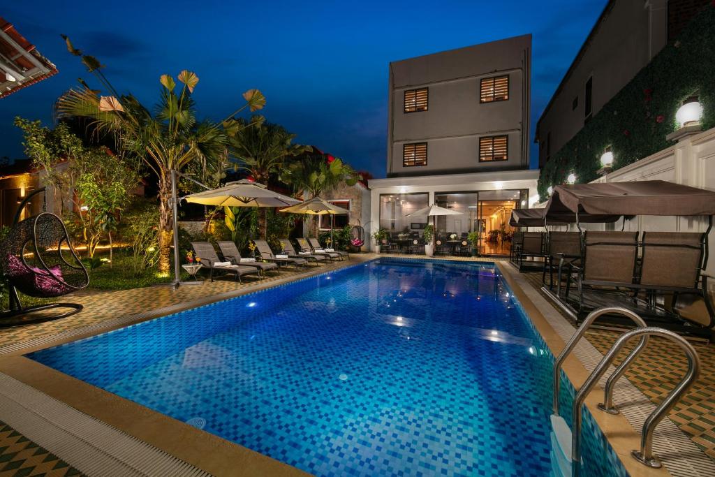 宁平Tam Coc Holiday Hotel & Villa的一座带椅子的游泳池以及一座建筑