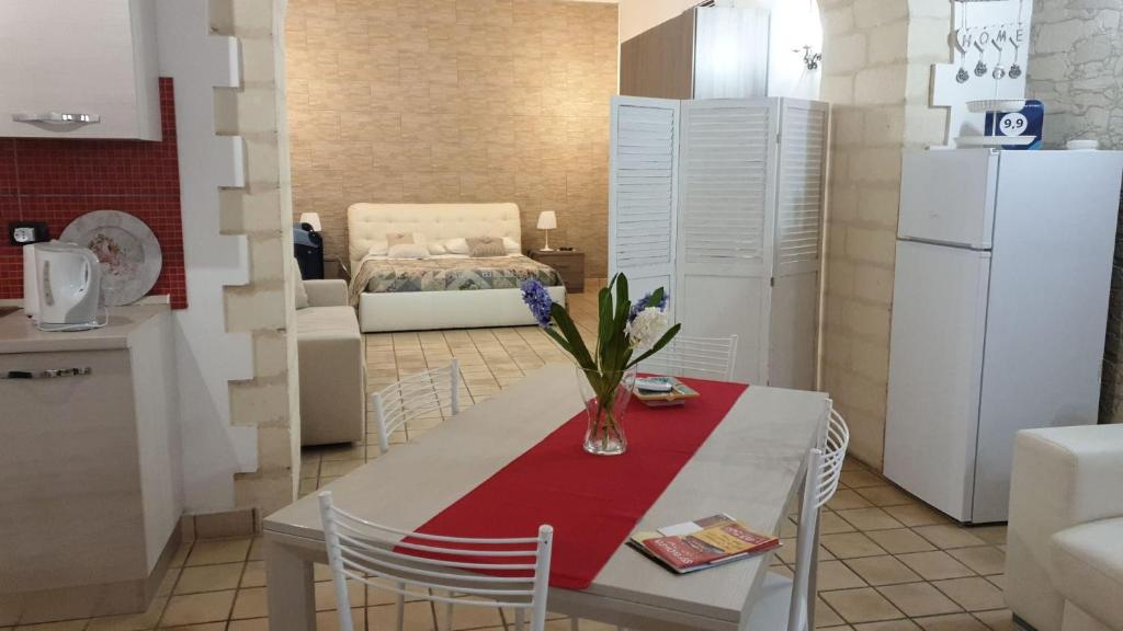 锡拉库扎Appartamento Dammuso Isola Di Ortigia的厨房配有一张桌子,上面放着花瓶