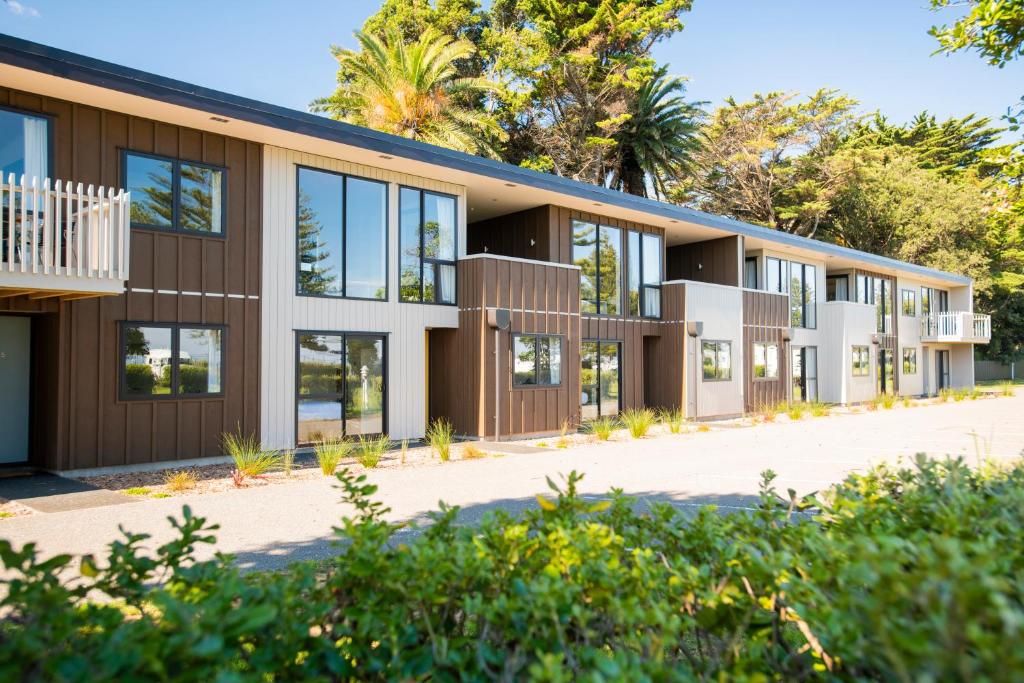 吉斯伯恩Waikanae Beach Ocean View Apartments的享有树木建筑的外部景色