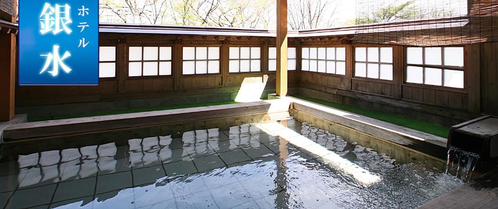 涩川市伊香保银水酒店的一座建筑中一座有水池的寺庙