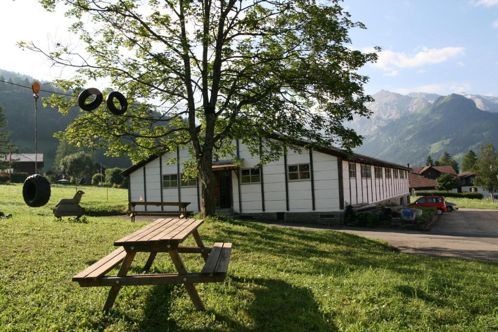 伦克Mountain Lodge Backpackercamp的坐在大楼前的草上野餐桌
