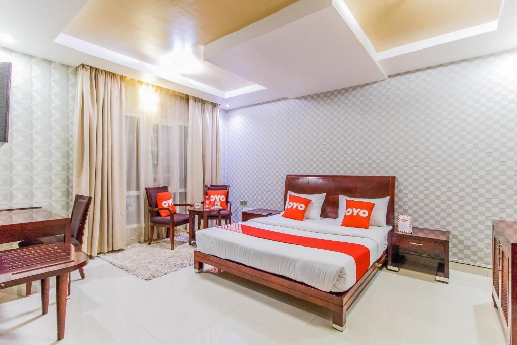 Ḩayl Āl ‘UmayrOYO 109 Al Thabit Modern Hotel Apartment的一间卧室配有一张带红色枕头的床