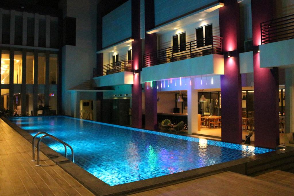 Batu AjiOS Style Hotel Batam Powered by Archipelago的大楼中央的大型游泳池