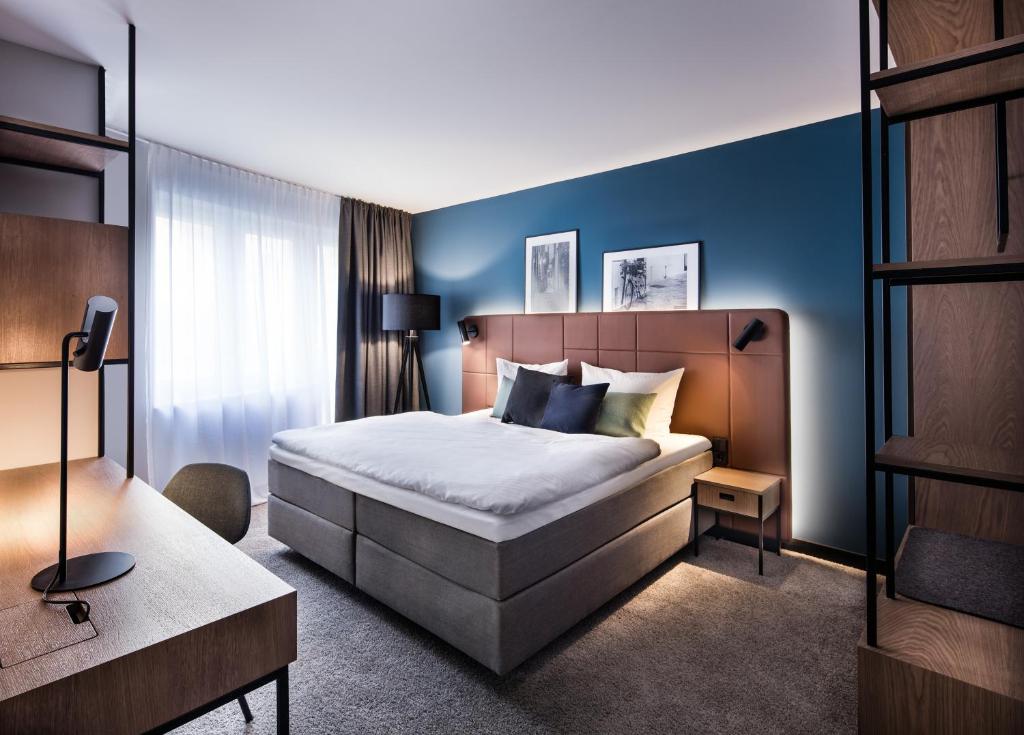 蒂宾根图宾根杜密兹酒店的一间卧室设有一张床和蓝色的墙壁