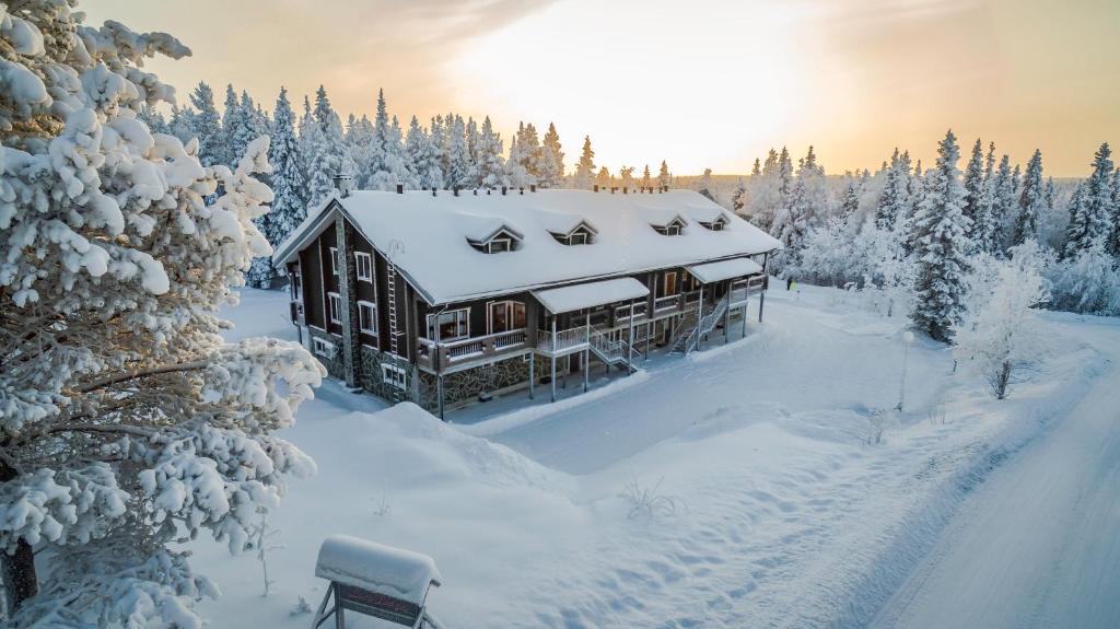 列维Levi Black Apartments的雪地里的小木屋,有雪覆盖的树木