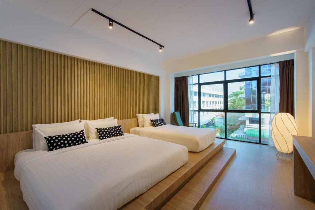 清迈Jiang Mai 81的一间卧室设有两张床和大窗户