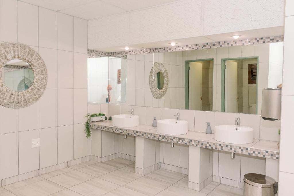 奥卡汉贾Okahandja Country Hotel的浴室设有3个水槽和2面镜子