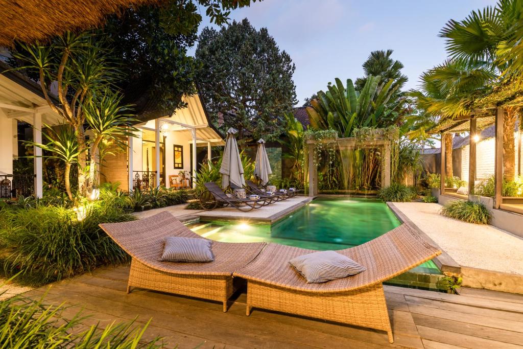 乌布卡姜街11号度假酒店的后院设有游泳池、桌子和椅子