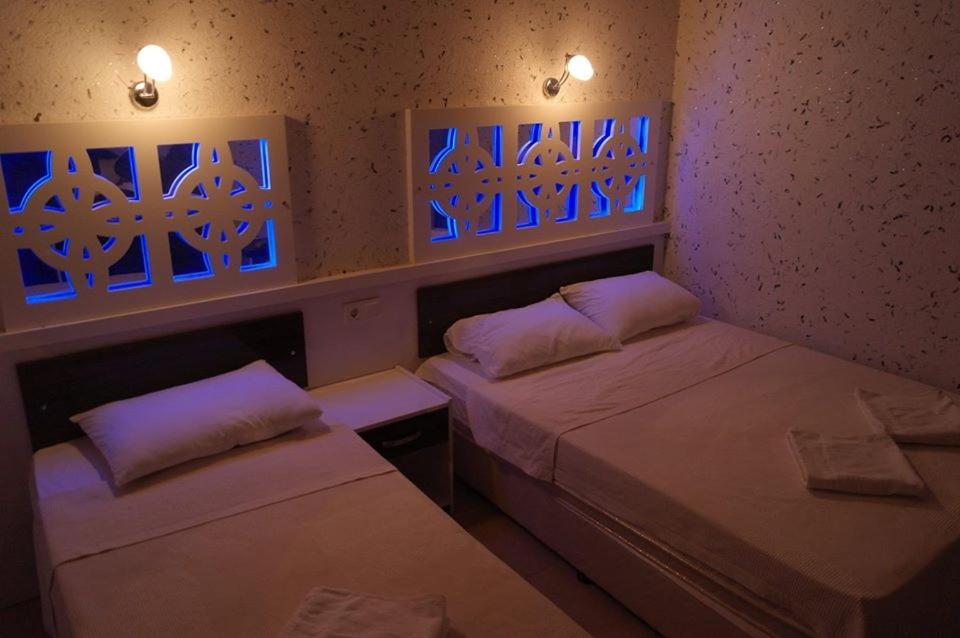 帕莫卡莱海豚尤努斯酒店的墙上有蓝色灯的房间里设有两张床