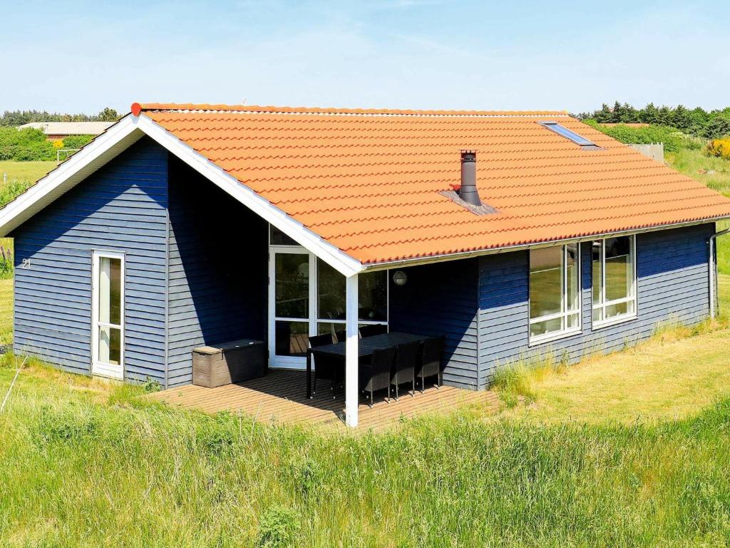 法贾德嘉德6 person holiday home in Ulfborg的蓝色的房子,在田野上设有甲板