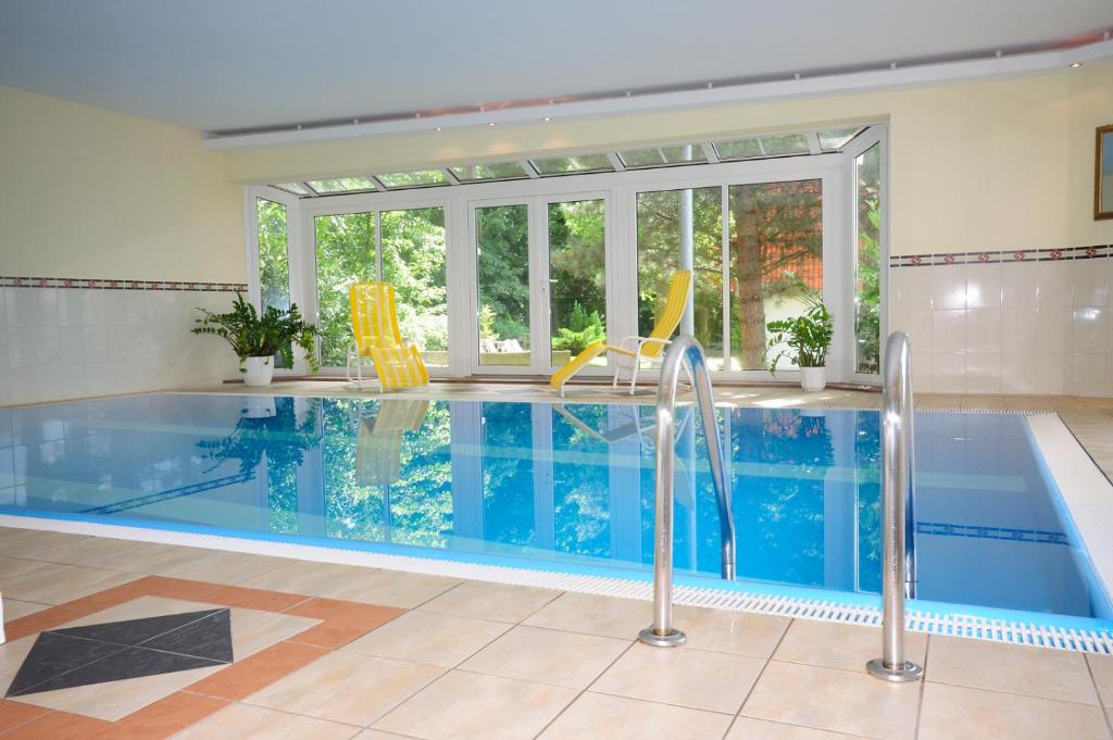 普劳西克鲁彻伯格公园酒店的一座带大窗户的房屋内的游泳池